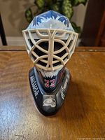 Front view of mini goalie mask showing cage, graphics, number 33 and display base