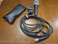 Microphone, XLR cable, clip, pouch laid on table