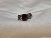 Front view showing central red stone and marcasite accents