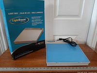 Original box and light box with power cord on table