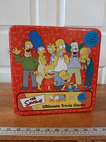Front of red tin showing Simpsons artwork and game title