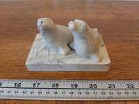 Front view of two-seal sculpture with ruler for scale