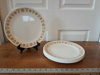 Stack of seven plates beside single displayed plate showing full pattern