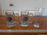 Full view of two mugs and pint glass with ruler for scale