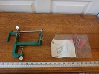 full view of green cast iron apple peeler with ruler for scale