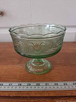 Side view of green pedestal bowl showing stippled texture and pedestal base