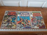 Group shot of three bagged King Conan comics with ruler for scale