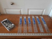 Geometry set package and six packaged rulers laid out on table