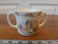 Front view of Royal Doulton Bunnykins two-handled mug showing Baby carriage scene