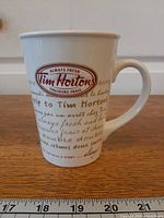 Front view of Tim Hortons mug with wrap-around text, ruler for scale