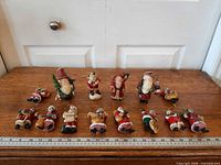 Group shot of all fourteen Santa ornaments on table