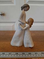 Full side view of figurine with ruler for scale