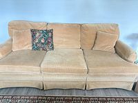 Front view of beige corduroy three-seat sofa with cushions