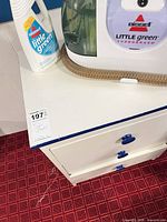 Cleaner, hose and cleaning solution bottle on cabinet