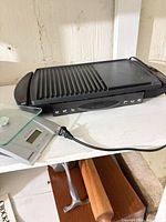 Grill and digital scale side by side showing overall items in lot