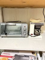 Front view of Black+Decker toaster oven and Mr. Coffee Jr. coffee maker with filters