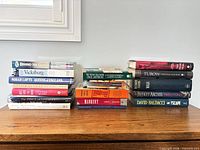 Two stacks of books on wooden surface showing spines