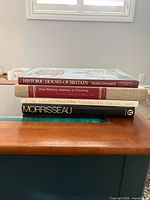 Stack of four hardcover books showing spines and dust jackets