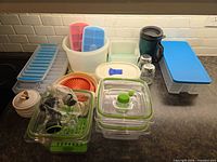 All items grouped on countertop showing variety of containers, trays, shakers, jar, travel mug