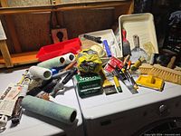 Overall lot on washer: brushes, rollers, trays, scrapers, steel wool, mixing paddle visible