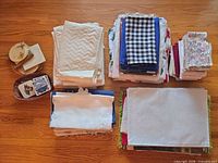 Overview of all stacked linens and coasters on floor