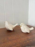 Both porcelain bird figurines on tabletop