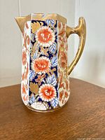 Front view showing Imari floral panels and gilt handle