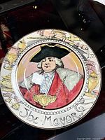 Front view of decorative plate showing portrait, rim design, and text