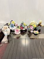 Overall view of seven porcelain floral pieces on table