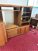 Front view showing entire entertainment center with drawers, TV opening, glass-door cabinet, and extra panel