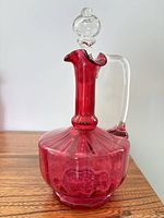 Full view of cranberry glass decanter showing stopper, handle and body