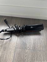 Flat iron coiled cord side view showing body and plug