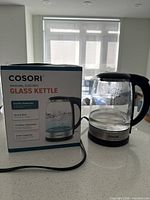 Retail box front and kettle on countertop