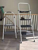 Front view of both ladders standing side by side on floor