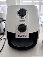 Front view of Starfrit air fryer showing analog dials and open cavity