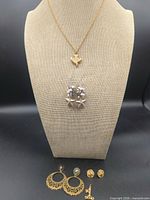 Full lot on display stand showing necklace, clip-on earrings, hoop earrings, stud earrings, lapel pin