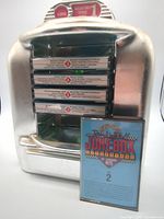 Front view showing jukebox holder with five cassettes and separate cassette Volume 2