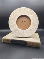 Circular carved frame resting on novel