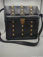 Front view of black leather Escada tote with gold studs
