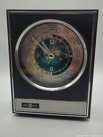 Front view of Howard Miller 8RW300 world time clock displaying dial and bezel