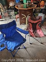 Blue and brown/red folding camp chairs side by side