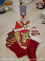 Group shot of Charlie Brown tree box, four stockings, Santa hat, antler headband and plaque