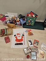 Wide view of assorted gift bags, boxes, Santa sack, crackers, cards and wrapping accessories spread on floor