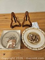 Both plates, two wooden stands and Poole information card displayed on table