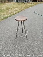 Full view of stool standing on pavement