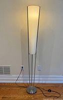 Full view of floor lamp showing base, stem, shade, and power cord