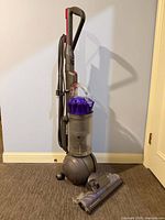 Full view of Dyson DC66 Ball Animal vacuum cleaner standing upright with floor head attachment