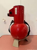 Side view of red Edmund Scientific Astroscan 2001 telescope on gray cradle with strap