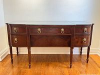 Front view of mahogany sideboard showing overall design and glass top