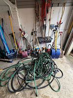 Overall lot showing hoses, hose reels, shovels and long-handled tools